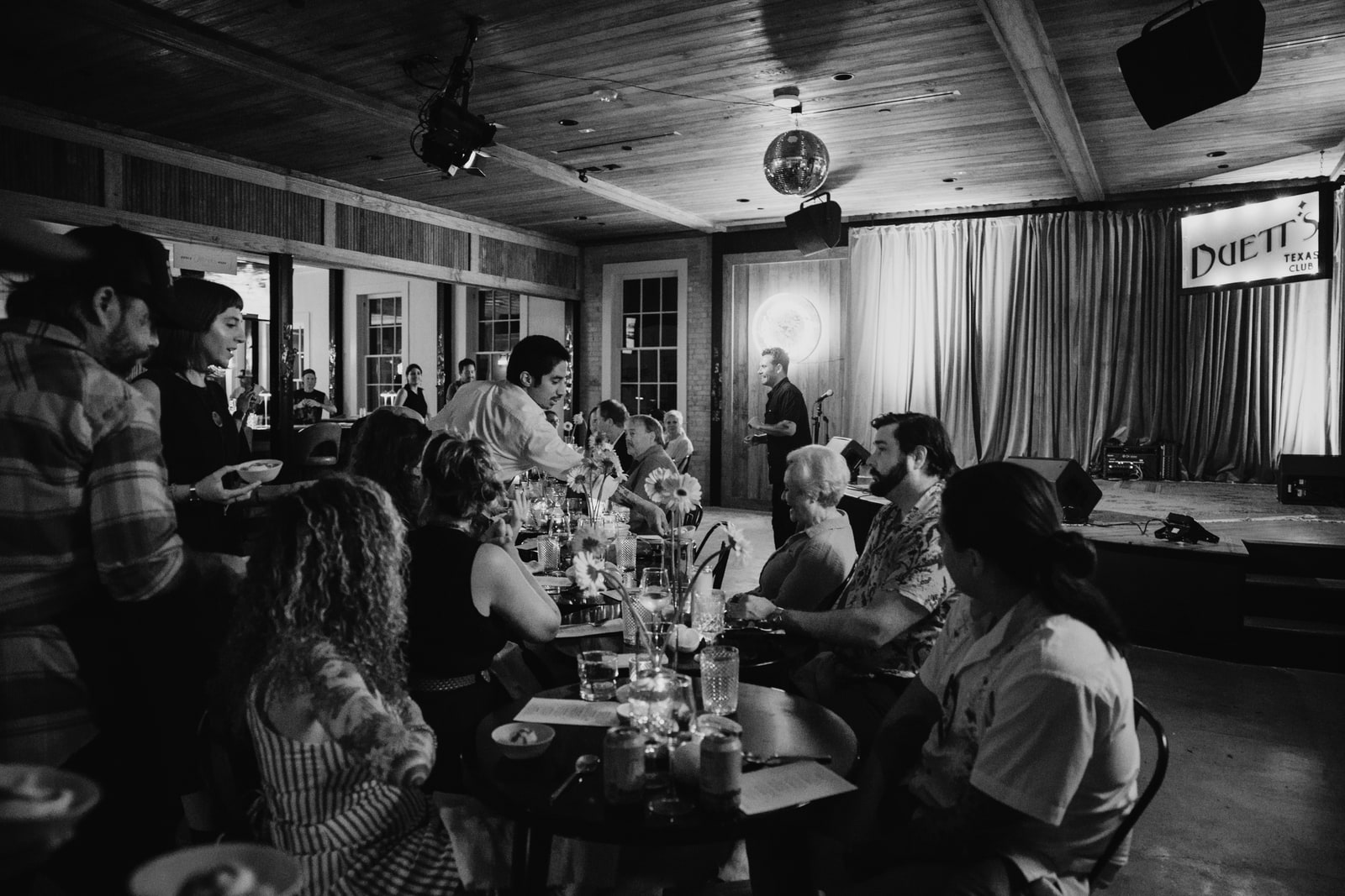 Guests sharing dinner while Gold Epicure staff serve the long table at Duetts.